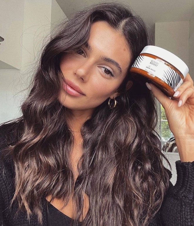 Influencer holding a hair product for a sponsored post